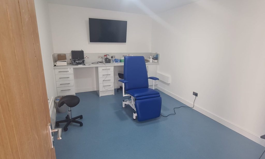 Inside view of a clinic featuring a patient chair and earwax removal tools, creating a professional treatment environment.