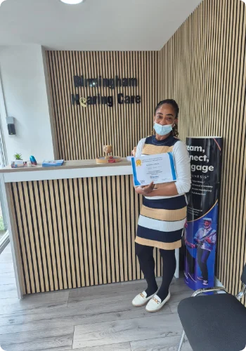 A Nurse who have received professional training in removing earwax showcasing her certification.