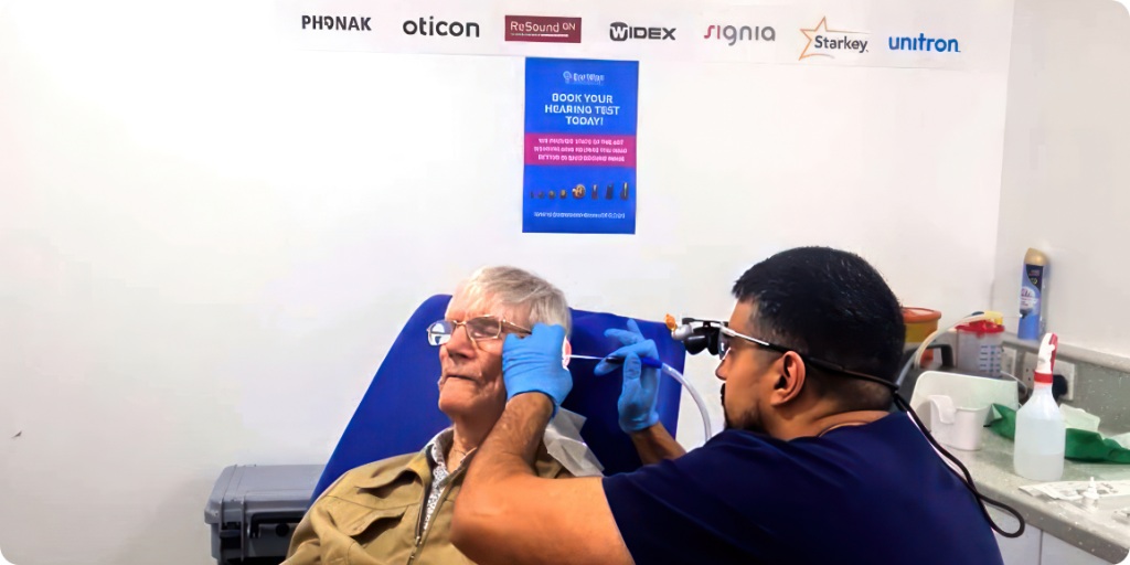 A professional ear care specialist using advanced equipment to perform earwax removal on a patient in a clinic.